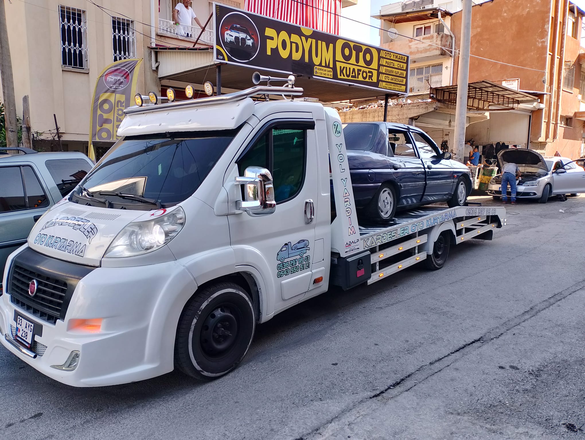 Oto kuaför önünde çekiciye yüklenmiş lacivert sedan — Kardeşler Oto Kurtarma