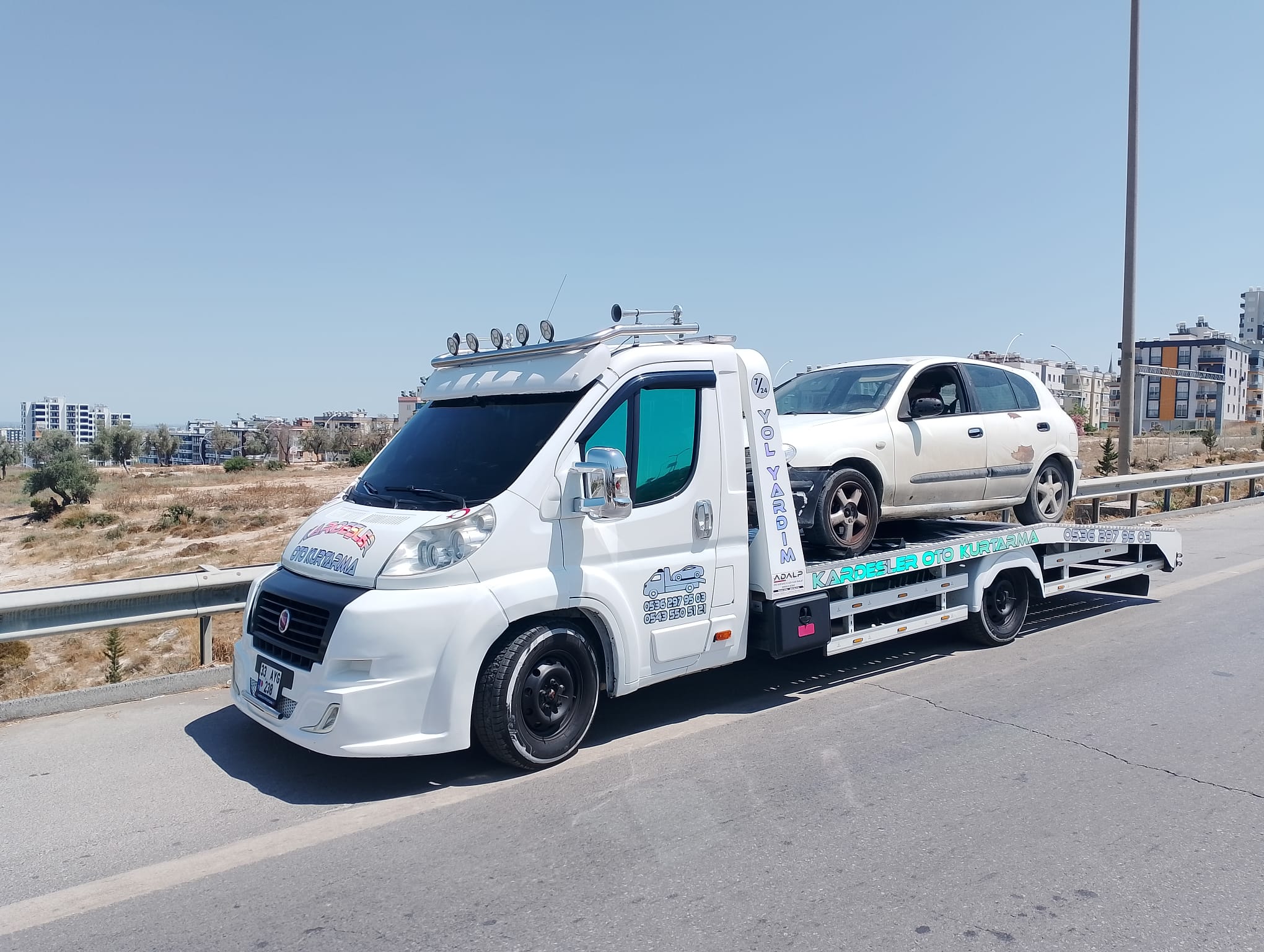 Kardeşler Oto Kurtarma çekicisi ile beyaz hatchback otomobil taşıma